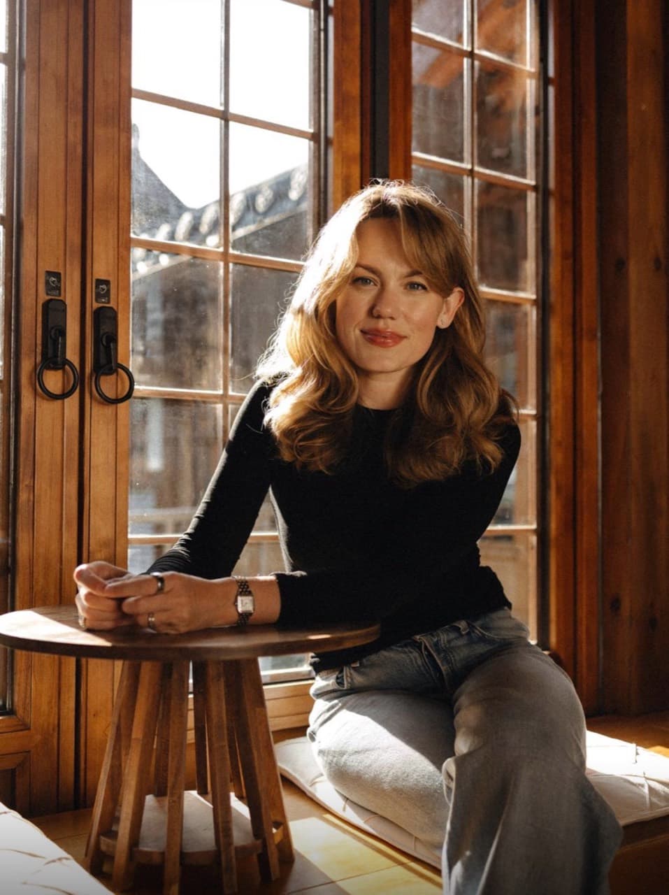 Oxana seated beside a sunlit window